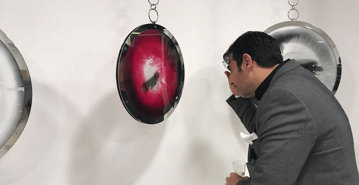 Dr. Andreas Ioannides taking a closer look of Eye of Compassion IX hanging at Diamonds are forever.