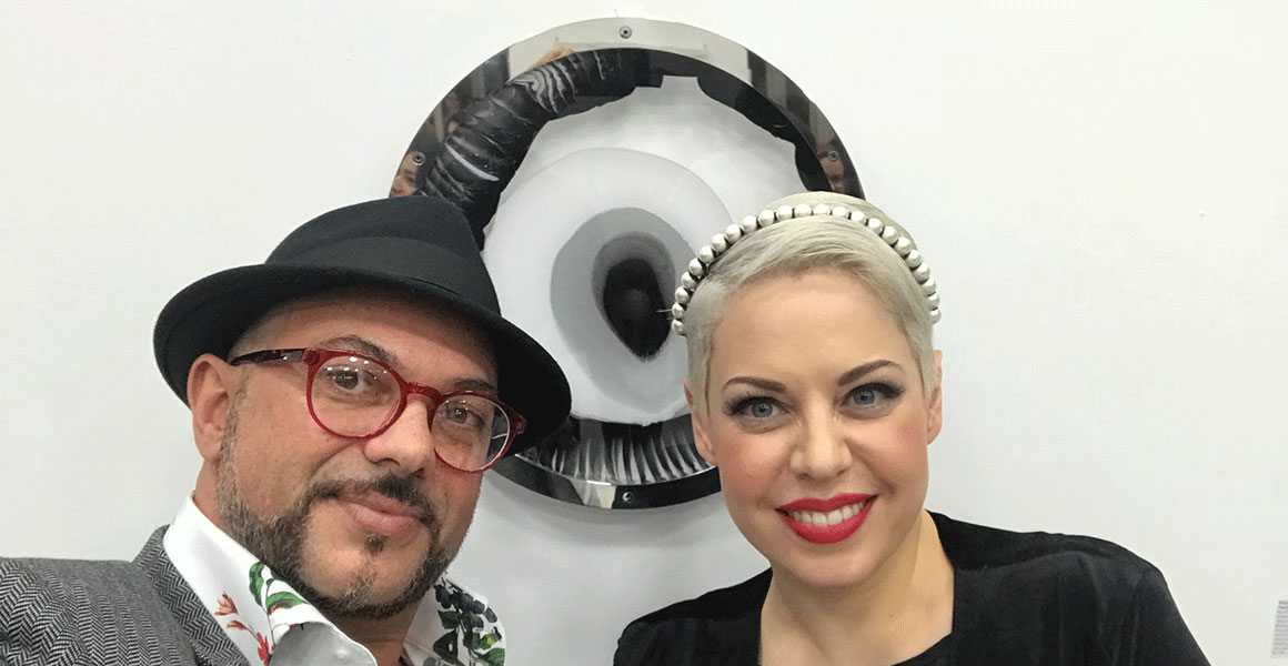 Yorgos Papadopoulos and Constandia Demitriadou of Cal Communications posing in front of Eye of Empowerment VIII displayed at The Collection Gallery.